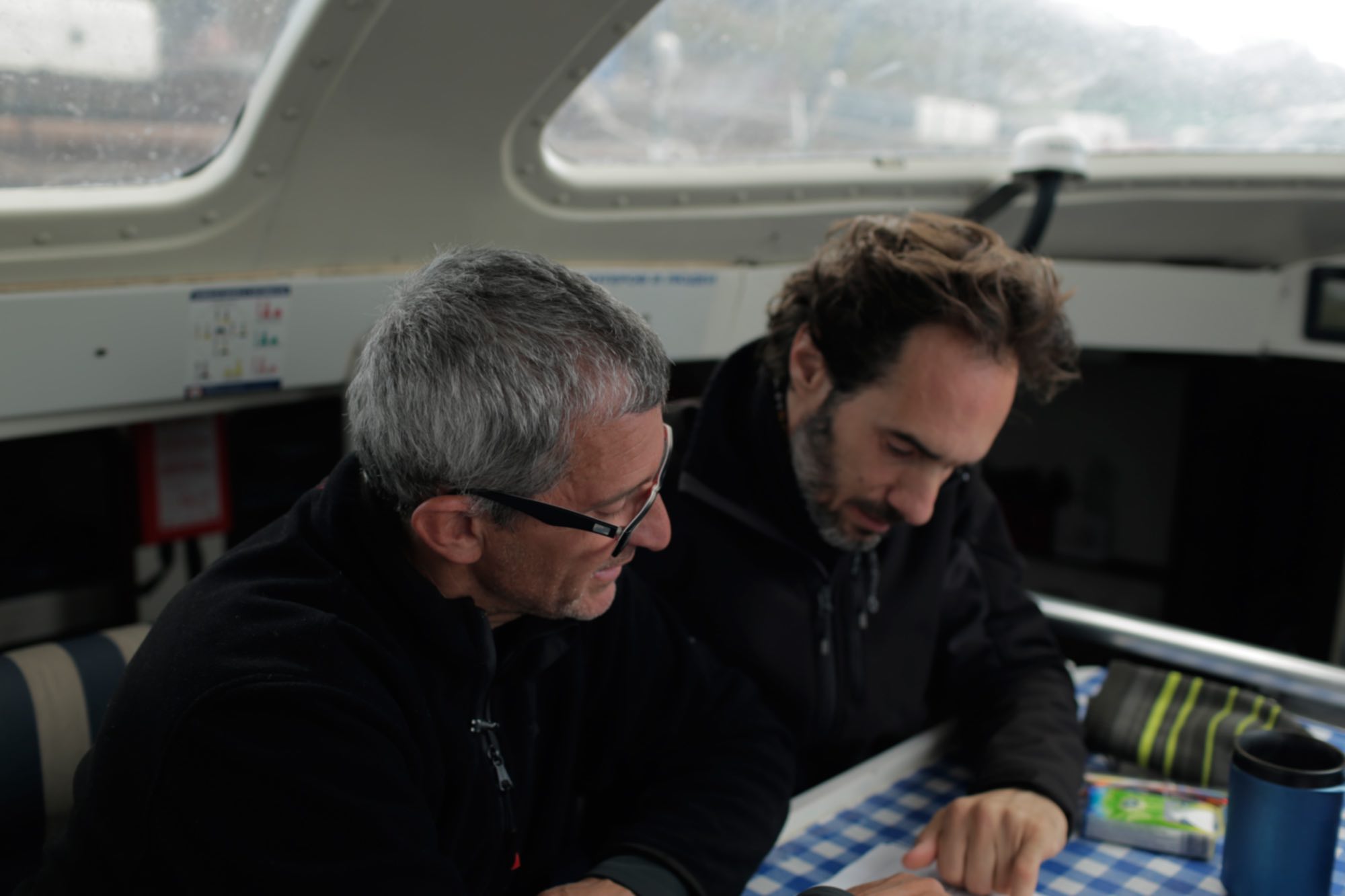 Albert Bargués observing a nautical chart together with the writer and scriptwriter Javier Argüello.